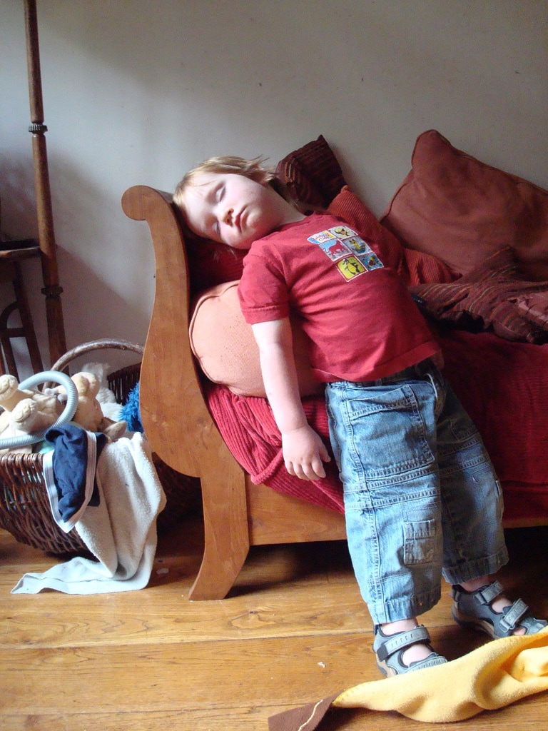 A kid sleeping, standing up