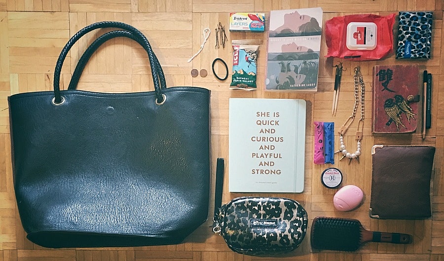 Picture of my purse with everything taken out (portable phone charger, lip liner, hand sanitizer, safety pins, healthy snack, enough juice)